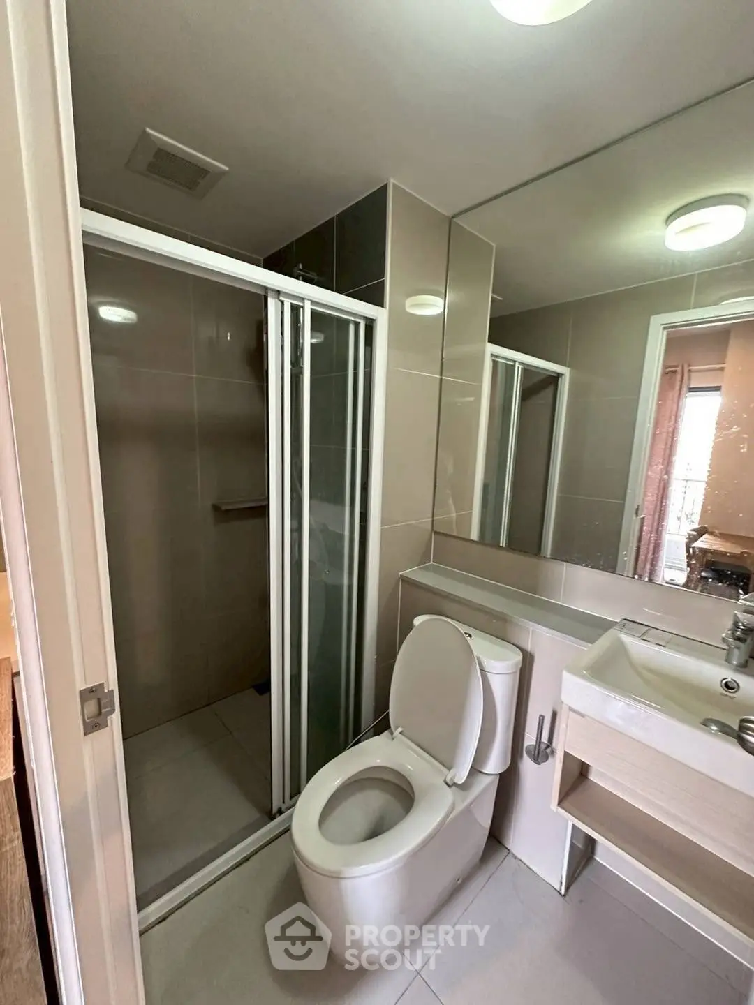 Modern bathroom with glass shower and sleek fixtures in a contemporary apartment.