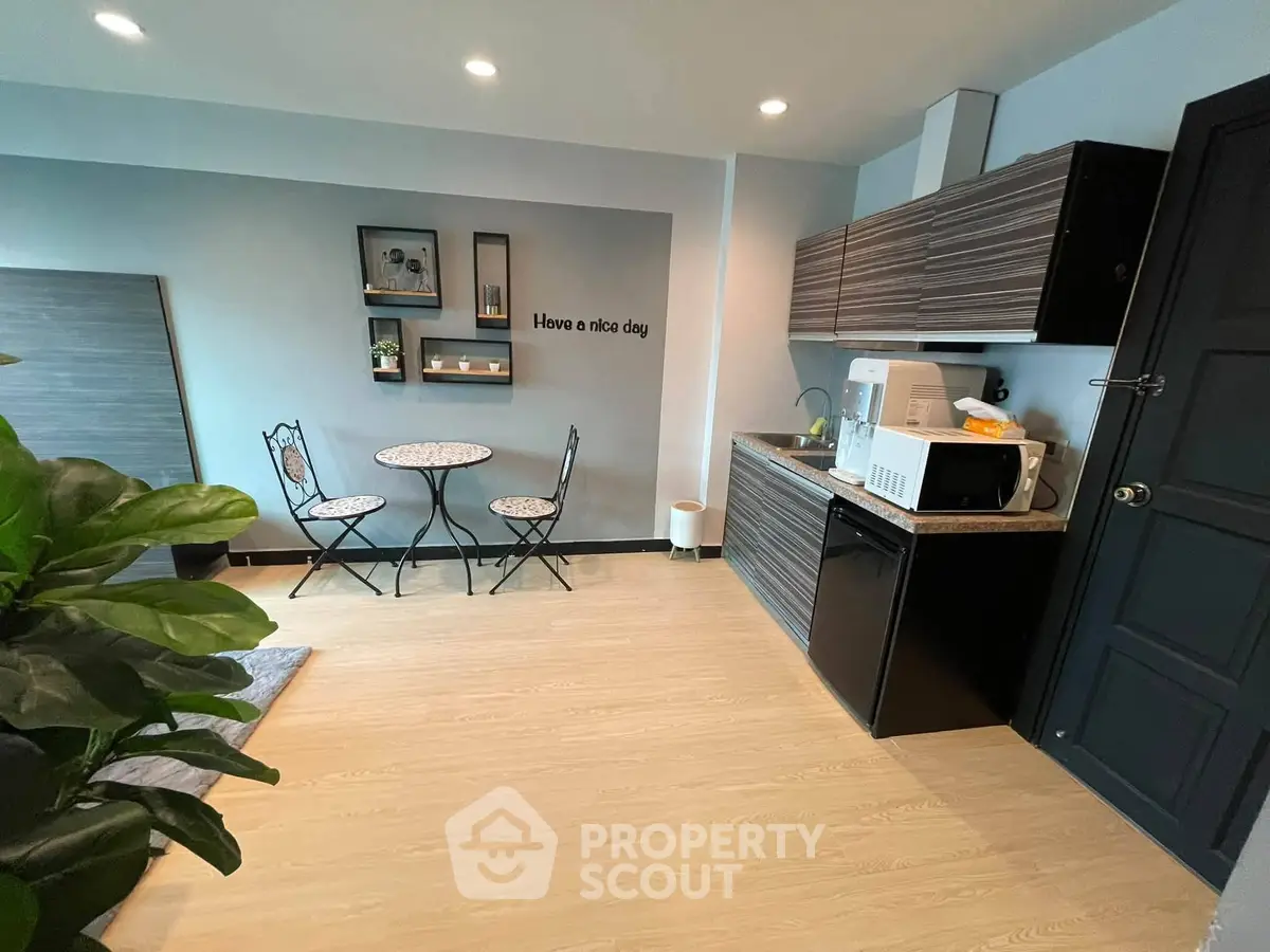 Charming studio kitchen with cozy dining area and modern appliances, perfect for urban living.