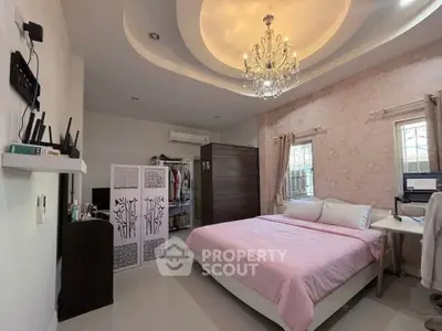 Elegant bedroom with chandelier, pink bedding, and stylish decor