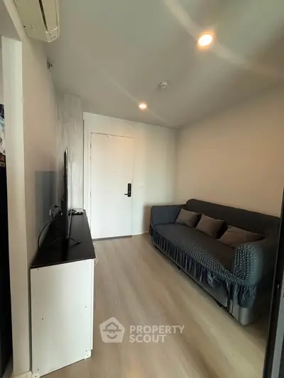 Cozy living room with modern decor and comfortable sofa in a compact apartment.