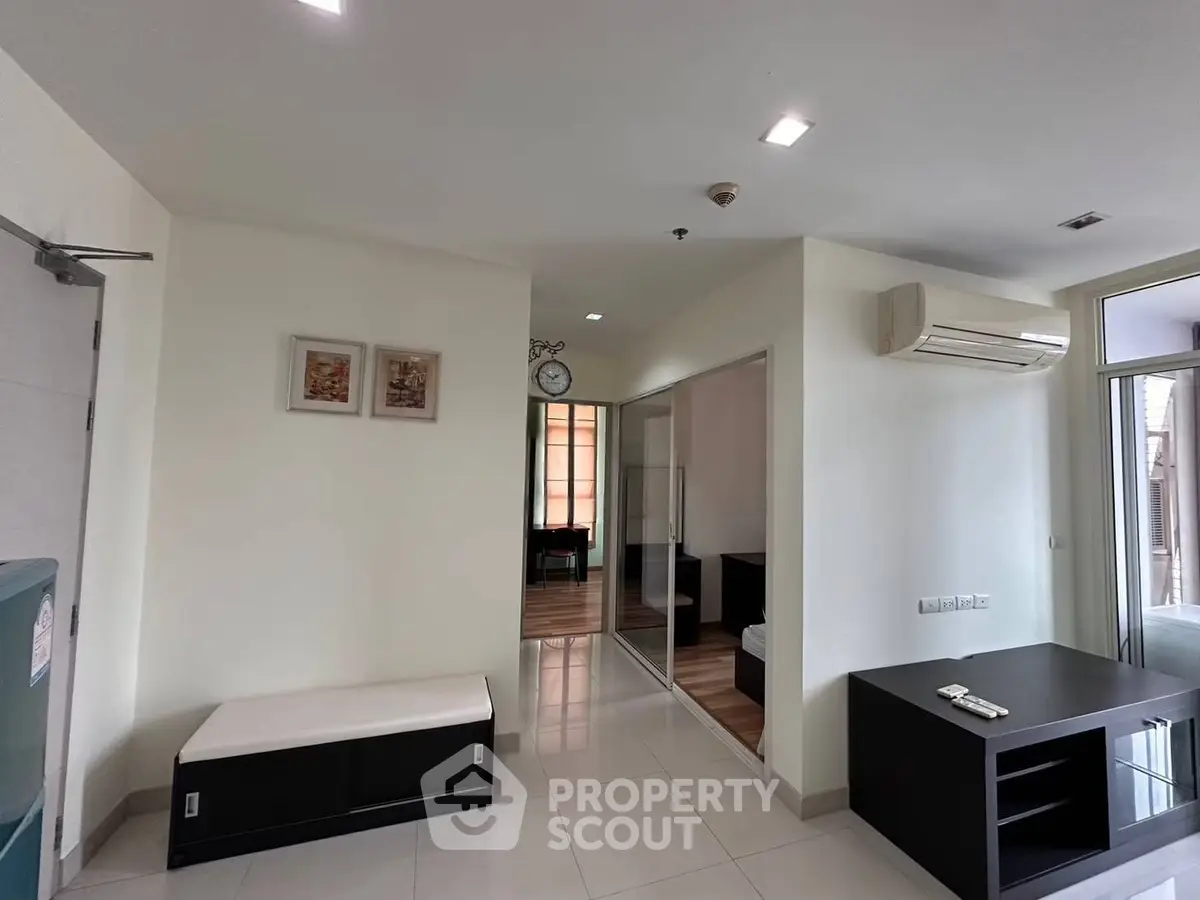 Modern living room with sleek design and air conditioning, featuring a minimalist aesthetic and ample natural light.
