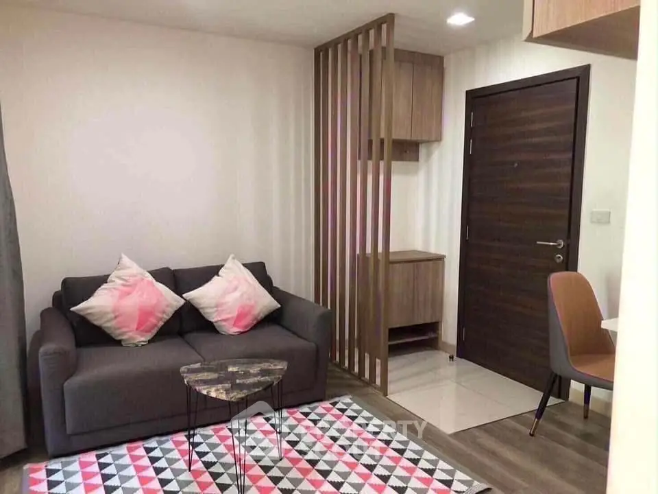 Modern living room with stylish sofa and geometric rug in cozy apartment.