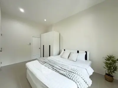 Spacious modern bedroom with minimalist decor and cozy bedding