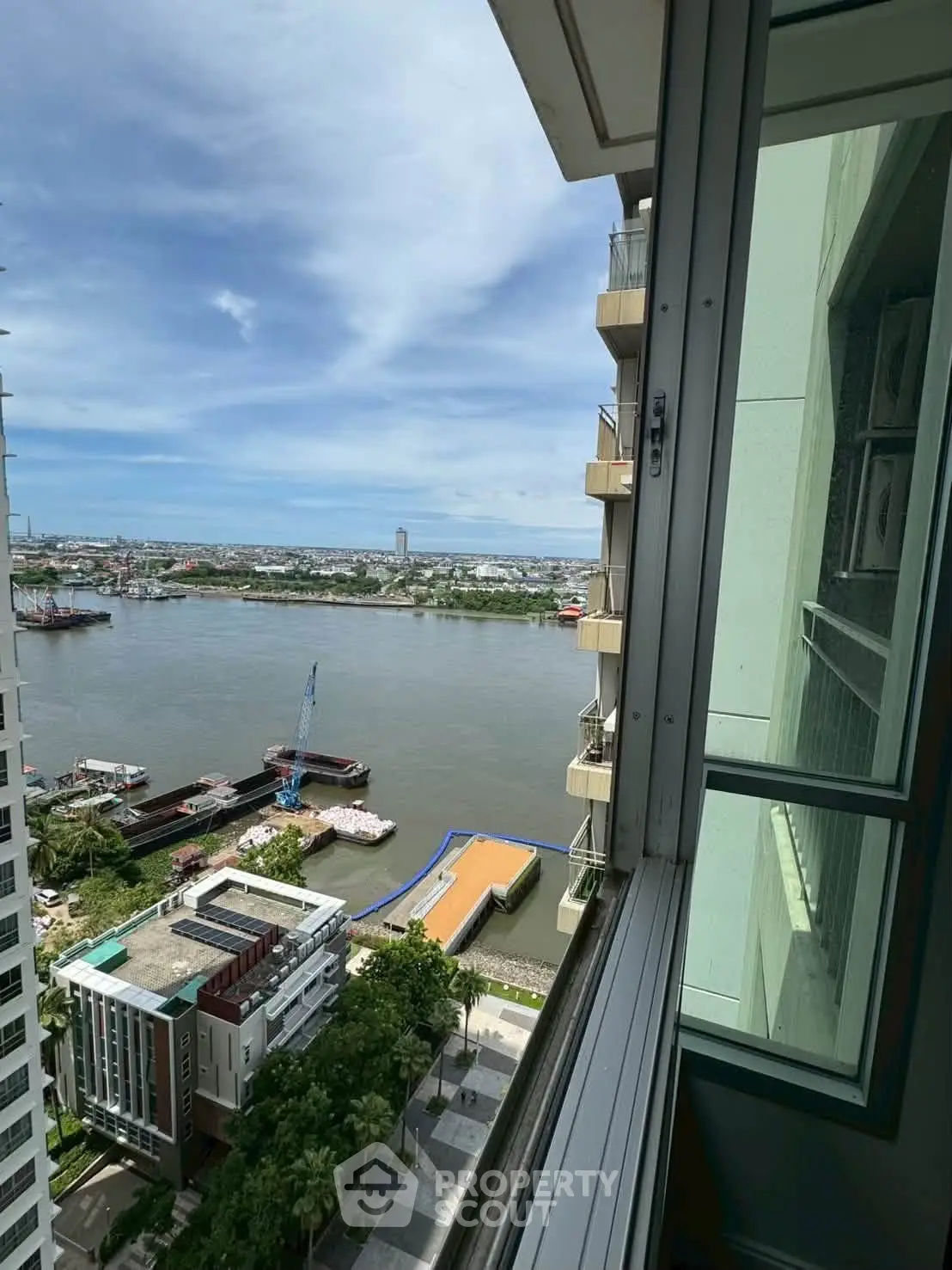 Stunning river view from high-rise apartment window, showcasing urban skyline and serene waterfront.