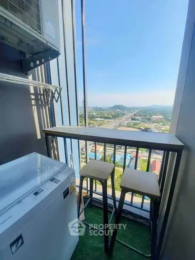 High-rise balcony with washer and scenic city view, perfect for urban living.