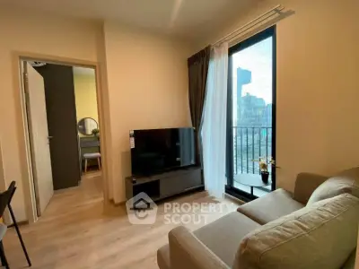 Modern living room with cozy sofa and large TV, featuring a balcony with city view.