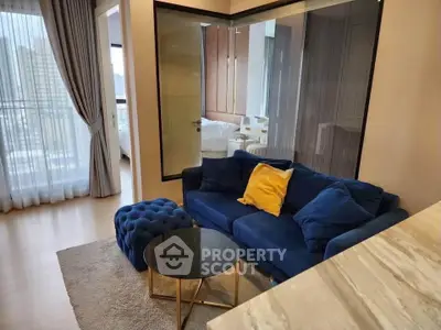 Modern living room with blue sofa and glass partition in stylish apartment