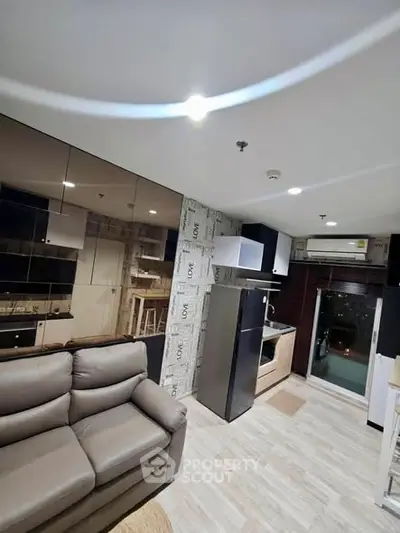Modern living room with sleek kitchen and balcony access in a stylish apartment.