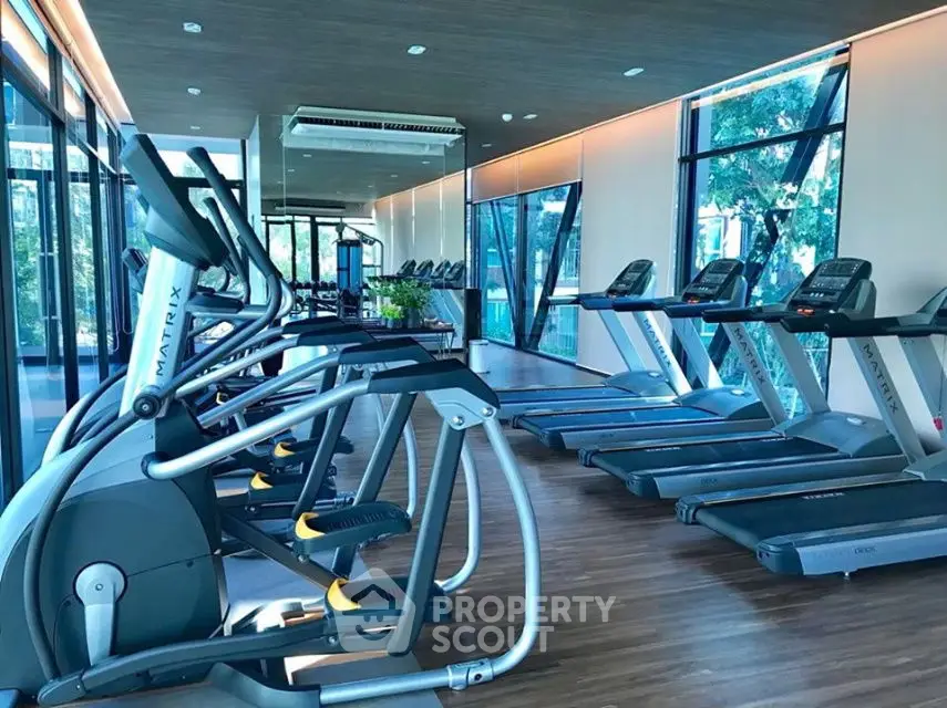 Modern gym with state-of-the-art equipment and large windows for natural light.