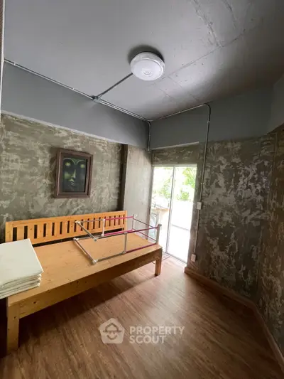 Industrial-style bedroom with wooden bed frame and rustic concrete walls.