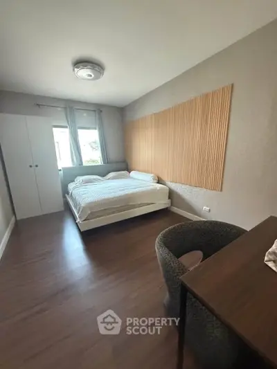 Spacious bedroom with modern decor and natural light, featuring a cozy bed and stylish furnishings.