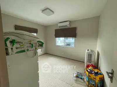 Cozy bedroom with air conditioning and ample natural light, perfect for a comfortable living space.