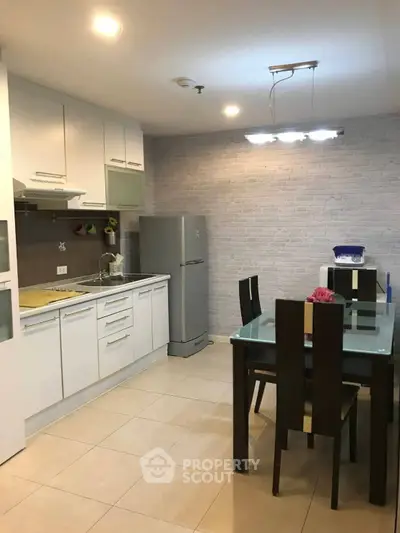 Modern kitchen with sleek white cabinets and dining area
