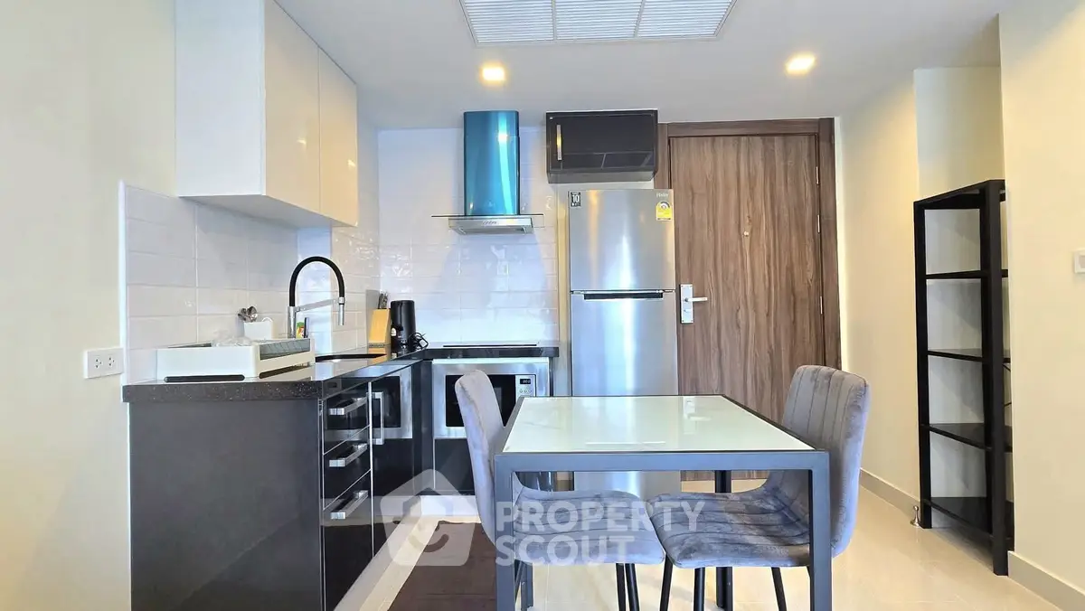 Modern kitchen with sleek appliances and dining area in a stylish apartment
