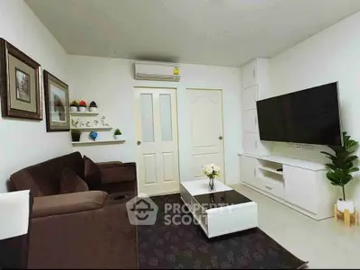 Modern living room with sleek furniture and large TV, perfect for relaxation and entertainment.