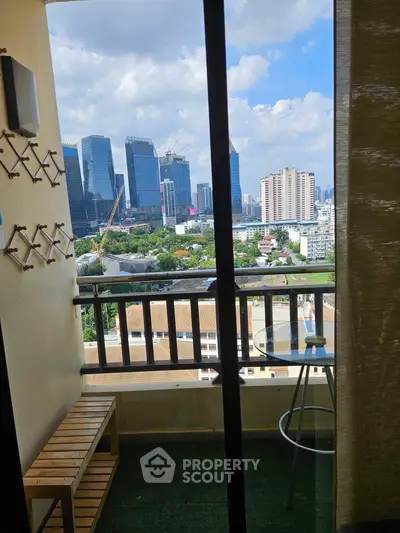 Stunning city view from a cozy balcony with modern furniture and skyline backdrop.