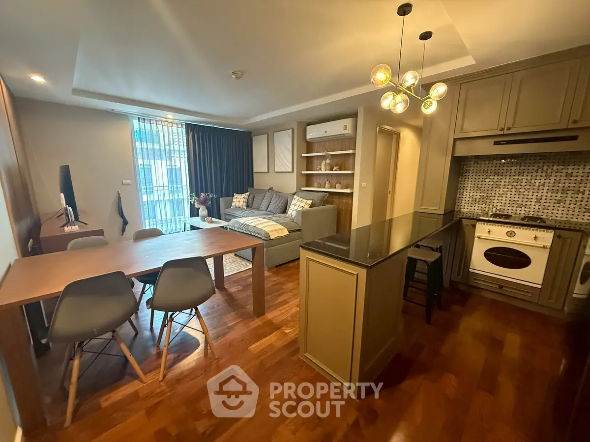 Modern open-plan living room and kitchen with stylish decor and hardwood floors.