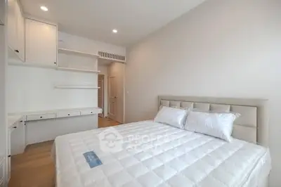 Spacious bedroom with modern design and ample storage in a bright apartment.