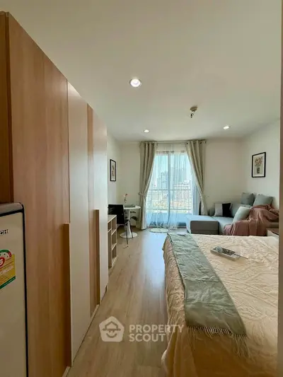 Modern bedroom with cozy decor and city view, featuring a comfortable bed and stylish furnishings.