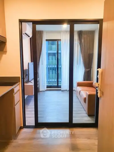 Modern apartment with open layout, sliding glass doors, and cozy living area with balcony view.