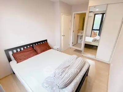Cozy bedroom with modern decor and mirrored closet doors, perfect for relaxation.