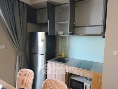 Modern kitchen with sleek cabinets, fridge, and built-in appliances in a cozy apartment.