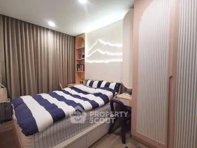 Modern bedroom with stylish lighting and cozy decor, featuring a comfortable bed and ample storage.