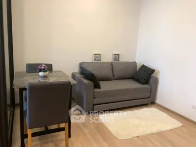 Cozy living room with modern gray sofa and dining table, perfect for small spaces.
