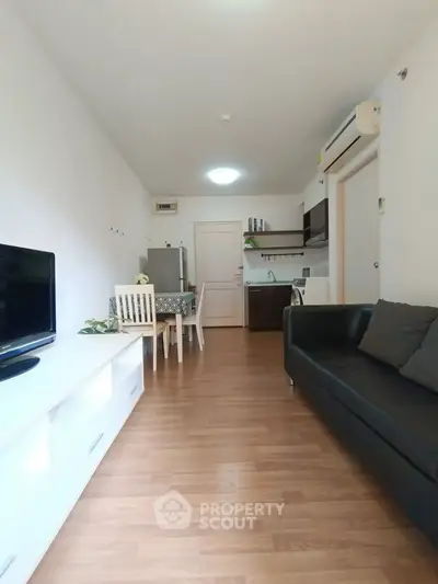 Modern living room with sleek furniture and open kitchen layout, perfect for cozy urban living.