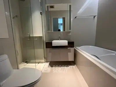 Modern bathroom with glass shower and bathtub in luxury apartment