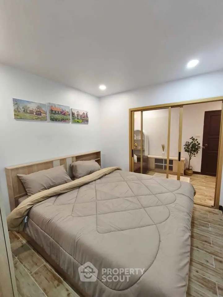 Cozy bedroom with modern decor and sliding doors in a stylish apartment.