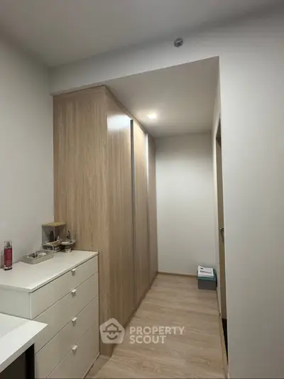 Spacious hallway with modern wooden cabinetry and sleek flooring