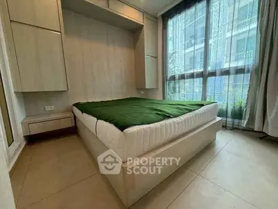 Modern bedroom with large windows and built-in storage in a stylish apartment.