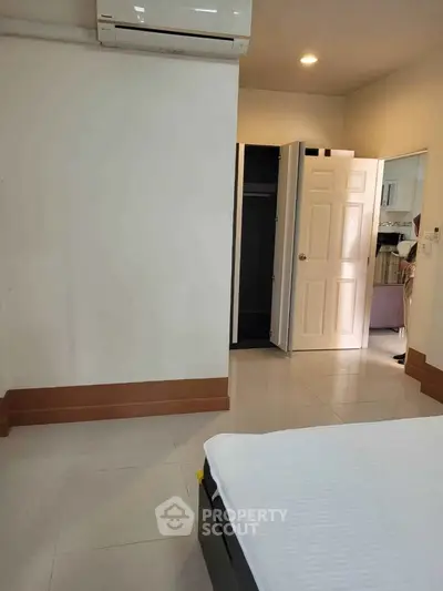 Spacious bedroom with air conditioning and open closet in modern apartment.
