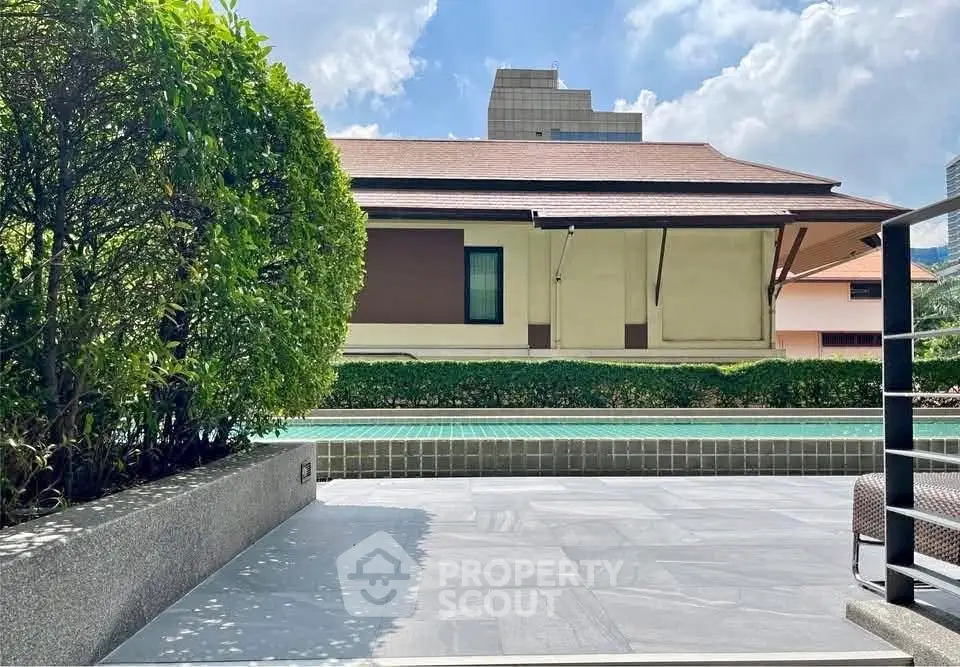 Luxurious outdoor pool area with lush greenery and modern architecture.