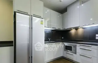 Modern kitchen with sleek white cabinets and built-in appliances