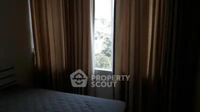 Cozy bedroom with window view and elegant curtains in a modern apartment.