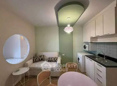 Charming compact living room with modern kitchenette and washing machine, ideal for urban living.