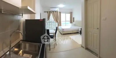 Modern studio apartment with open layout, featuring a compact kitchen and cozy bedroom area.