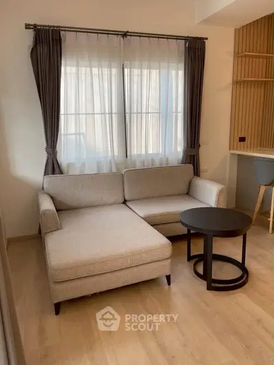 Modern living room with stylish beige sofa and elegant curtains, perfect for cozy relaxation.