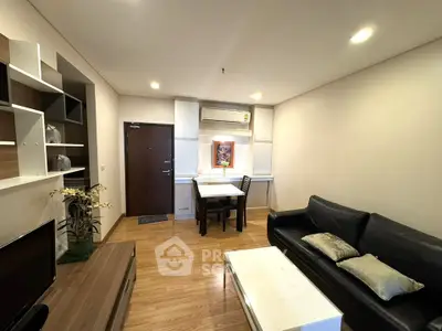 Modern living room with sleek furniture and wooden flooring in a cozy apartment.