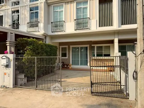 Charming townhouse exterior with gated entrance and lush greenery, perfect for modern living.