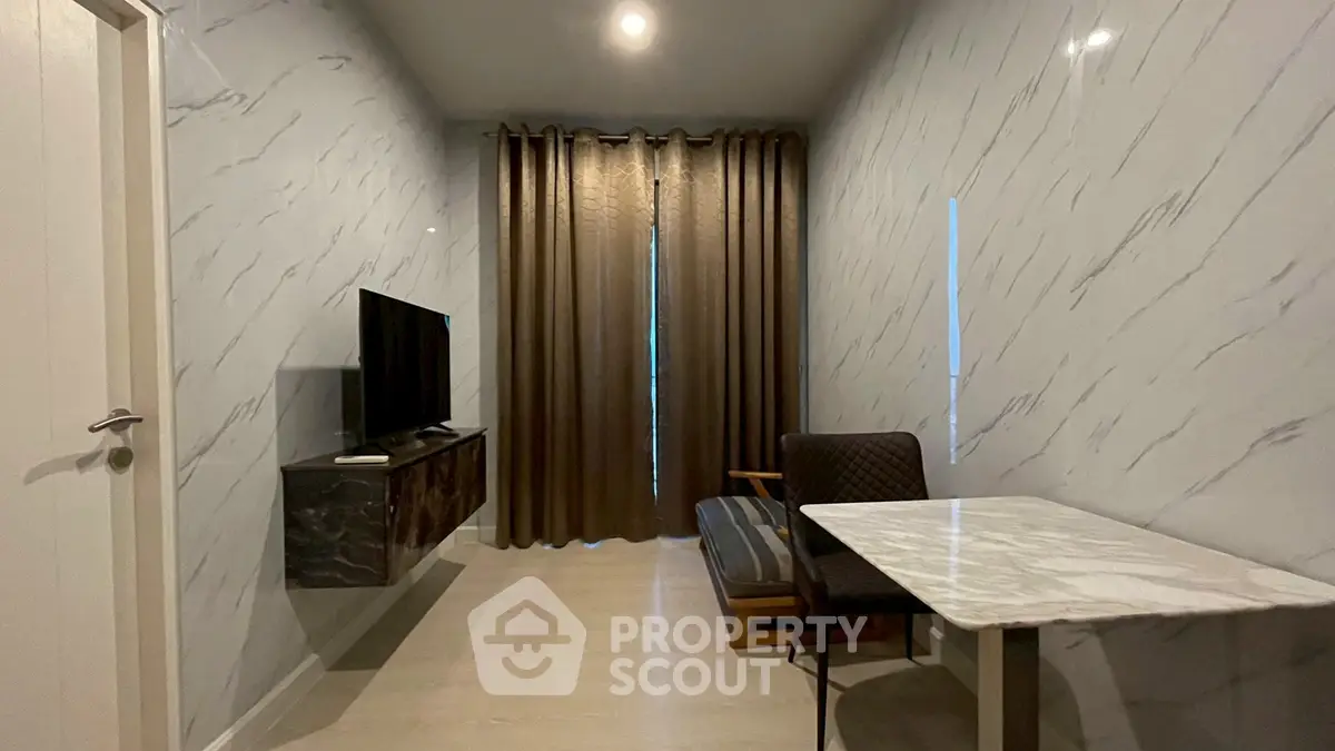 Modern living room with marble walls, sleek TV setup, and elegant curtains.