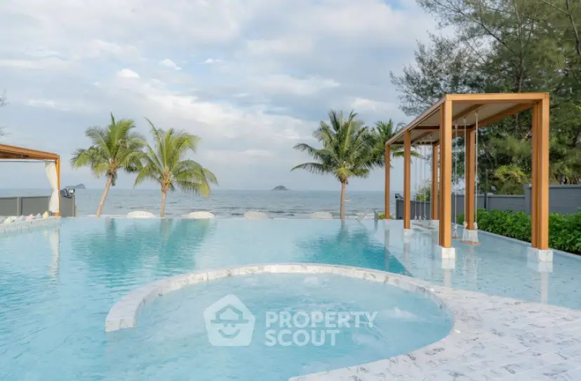 Luxurious beachfront pool with stunning ocean view and palm trees
