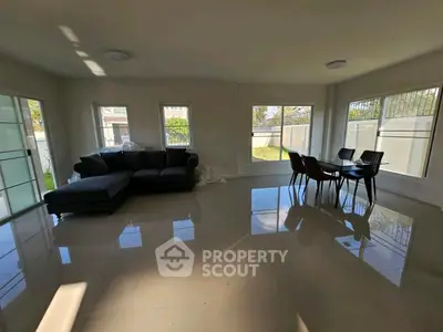 Spacious living room with modern furniture and large windows offering natural light.