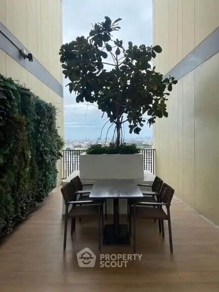 Stylish balcony with dining set and lush greenery offering a serene city view.