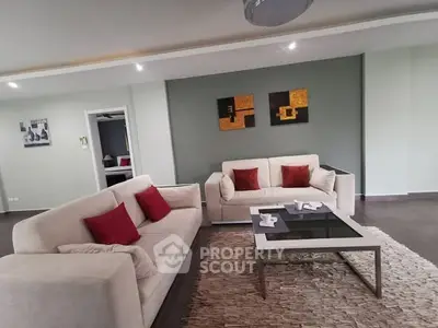 Spacious modern living room with stylish decor and comfortable seating.