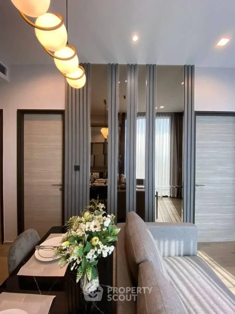 Modern living room with elegant decor and stylish lighting, featuring a cozy dining area and contemporary design.