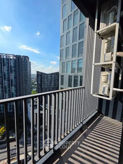 Modern high-rise balcony with cityscape view and sleek railing design.
