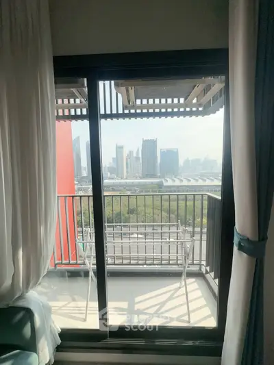 Stunning city view from modern apartment balcony with sleek glass doors and cozy seating area.